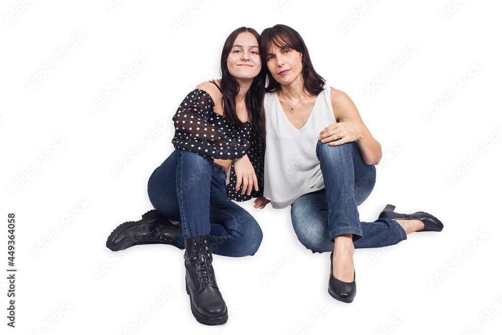 Mother and teenage daughter seated on a white background Mother and teenage daughter seated on a white background