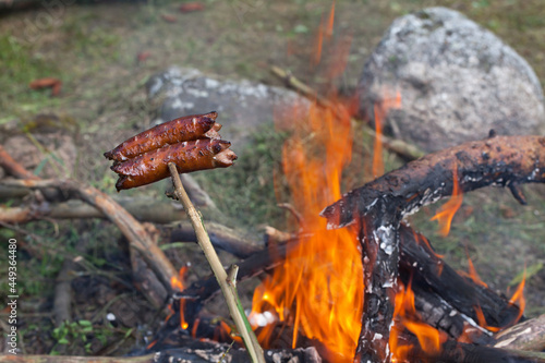 Sausage scooped onto a stick, fried over a campfire.