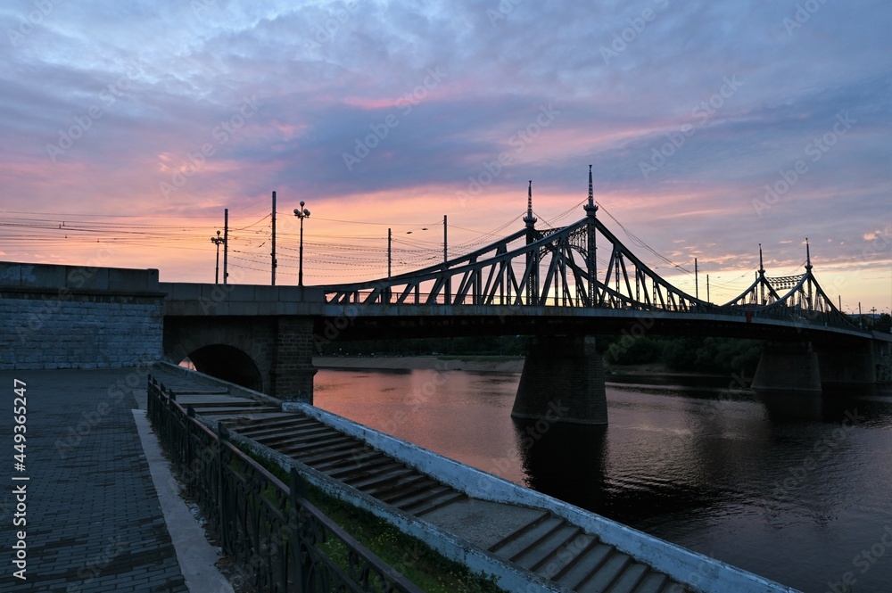 Urban landscape and a beautiful sunset in the evening on the river embankment with a bridge. Copy space