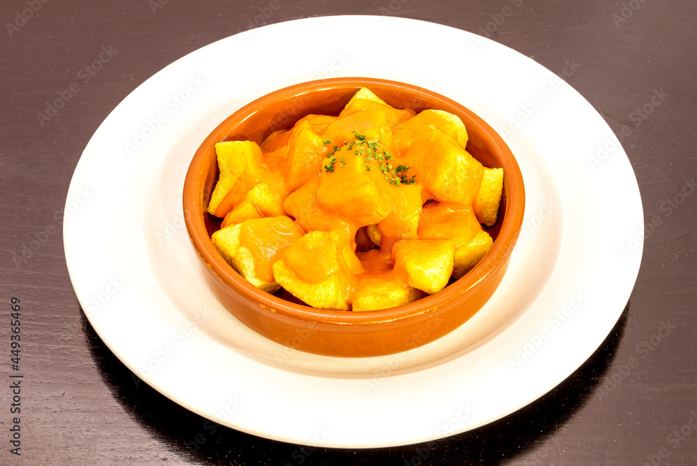 Popular Madrid tapa of patatas bravas served in a clay pot Popular Madrid tapa of patatas bravas served in a clay pot
