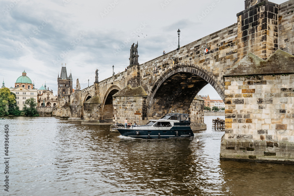 Fototapeta premium Charles Bridge,luxury boat on Vltava river,Prague, Czech Republic. Buildings and landmarks of Old town on summer day. Amazing European cityscape.Popular tourist destination.Colorful urban city scene