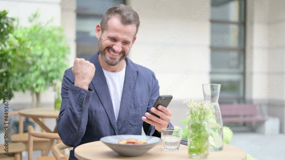 Man Talking on Smartphone, Sitting in Outdoor Cafe, Front Pose Man Talking on Smartphone, Sitting in Outdoor Cafe, Front Pose