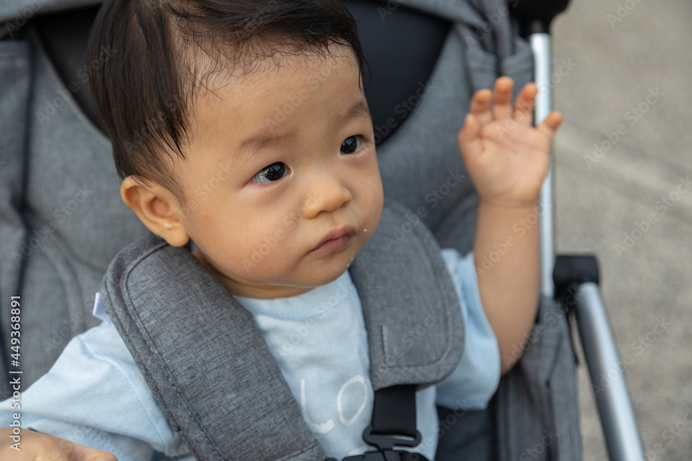 Closeup portrait image of Happy and cute Asian Chinese baby boy sitting on stroller at park during evening Closeup portrait image of Happy and cute Asian Chinese baby boy sitting on stroller at park during evening