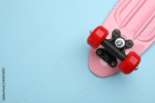 Skateboard on turquoise background, top view. Space for text