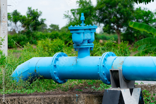 Wallpaper Mural A large blue water pipe runs through a small canal on the other side of the road in a close-up view. Torontodigital.ca