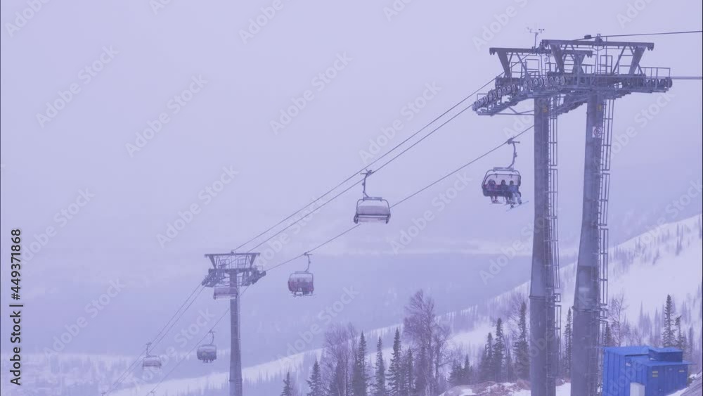 people in warm suits ride poma lift sitting in cabins over snowy slope while heavy mist coming on nasty winter day timelapse people in warm suits ride poma lift sitting in cabins over snowy slope while heavy mist coming on nasty winter day timelapse
