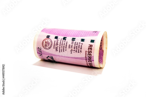 Indian two thousand rupees rolled up banknote isolated on white background.