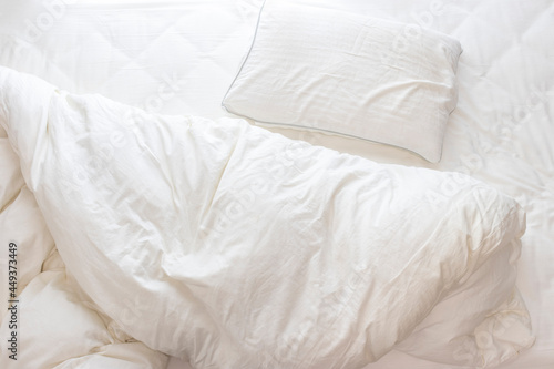 ベッドの乱れた布団と枕 photo