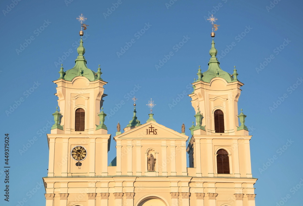 Fototapeta premium Towers of an ancient gothic catholic basilica on a blue sky background