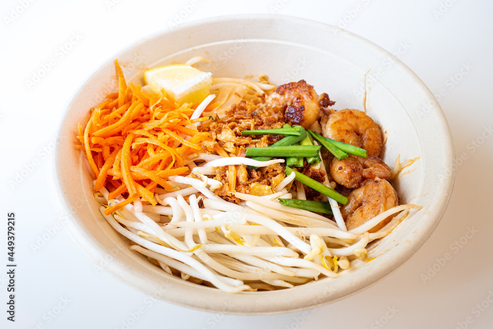 Asian dish Pad Thai prepared with noodles, grilled shrimps, soy sprouts, carrots pieces and sprinkle with peanuts to serve a delicious meal