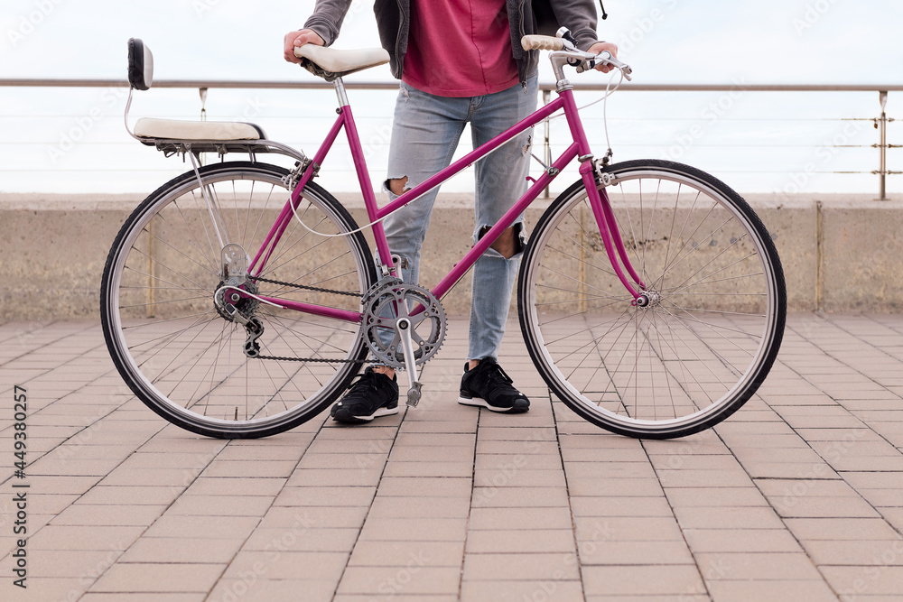 unrecognizable young man holding a retro bike unrecognizable young man holding a retro bike