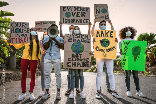 Group of activists protesting for climate change during covid19 - Multiracial people fighting on road holding banners on environments disasters - Global warming concept photo