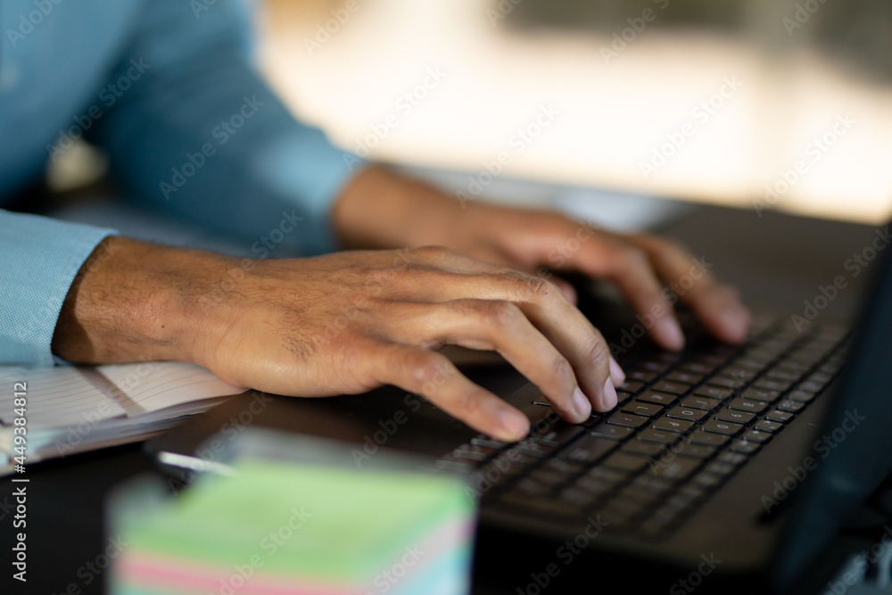 Mixed race businessman working at night using laptop Mixed race businessman working at night using laptop