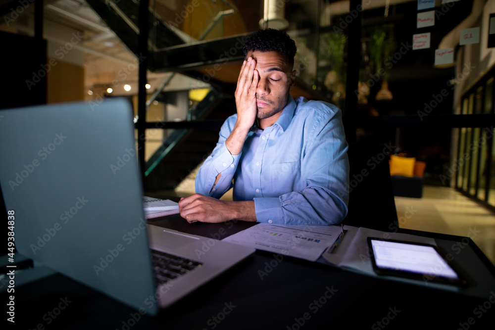 © Wavebreak Media - Mixed race businessman working at night, sitting at desk and using laptop © Wavebreak Media - Mixed race businessman working at night, sitting at desk and using laptop
