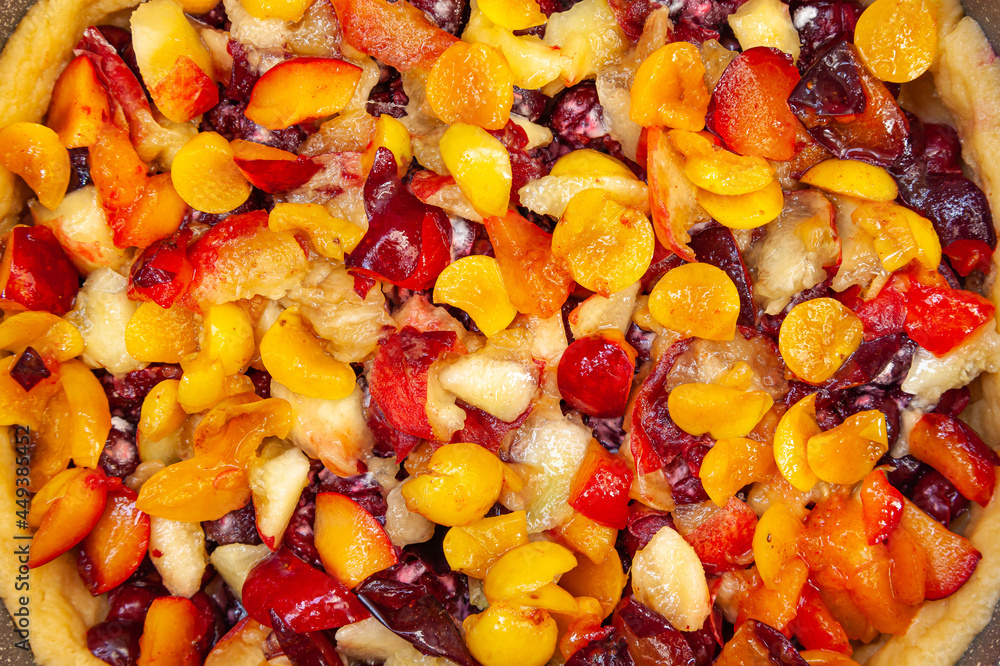 Fruit pie filling, top view. Pieces of peaches, cherries and plums on a pie.