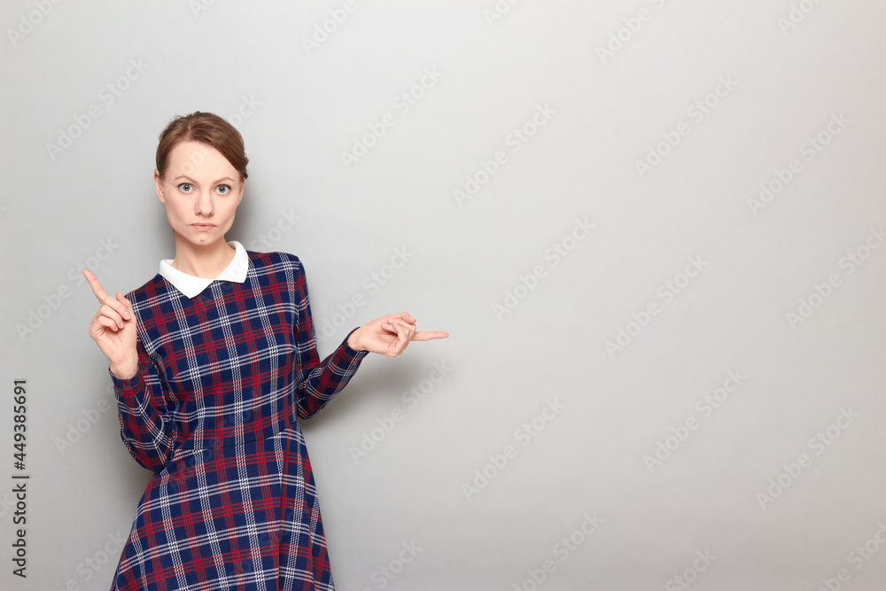 Portrait of concentrated woman pointing with fingers at copy spaces Portrait of concentrated woman pointing with fingers at copy spaces