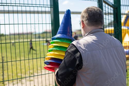 Fototapeta Naklejka Na Ścianę i Meble -  The man is holding sports equipment. The teacher is preparing the baton.