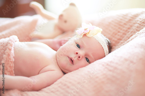 A newborn baby lies in her mother's arms. A beautiful baby of European appearance is sleeping.