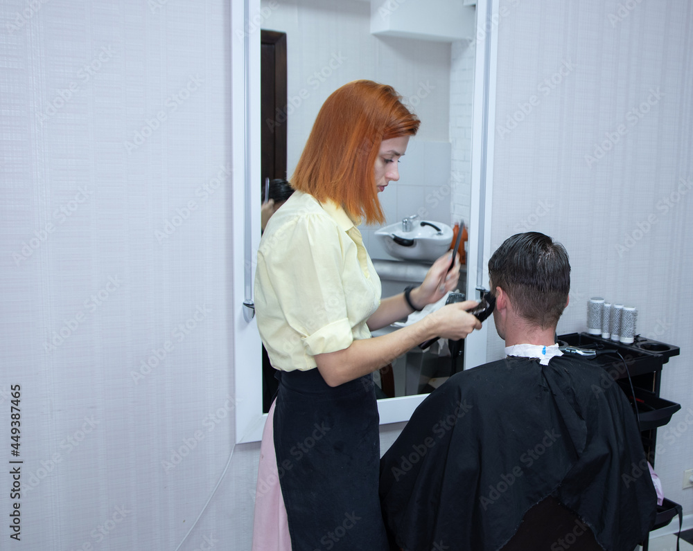 hairdresser girl cuts a guy's hair in a beauty salon hairdresser girl cuts a guy's hair in a beauty salon