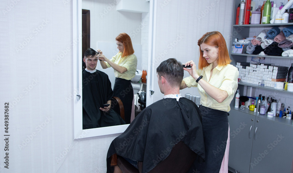 hairdresser girl cuts a guy's hair in a beauty salon hairdresser girl cuts a guy's hair in a beauty salon