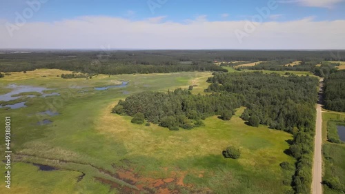 A bird's-eye view of the Siemianówka dam reservoir in the upper Narew valley.A bird's-eye view of two water pools separted track connected by a bridge.  photo