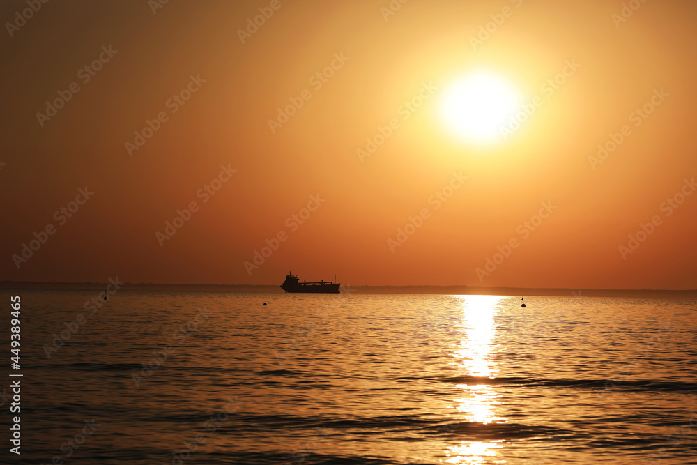 sunrise at sea and ship on the horizon