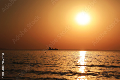 sunrise at sea and ship on the horizon © prohor08