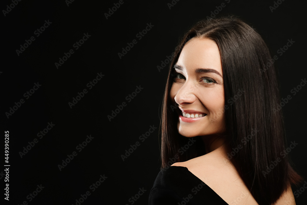 Portrait of pretty young woman with gorgeous chestnut hair and charming smile on black background, space for text Portrait of pretty young woman with gorgeous chestnut hair and charming smile on black background, space for text