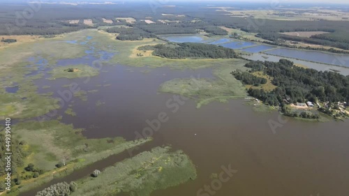 A bird's-eye view of the Siemianówka dam reservoir in the upper Narew valley.A bird's-eye view of two water pools separted track connected by a bridge.  photo