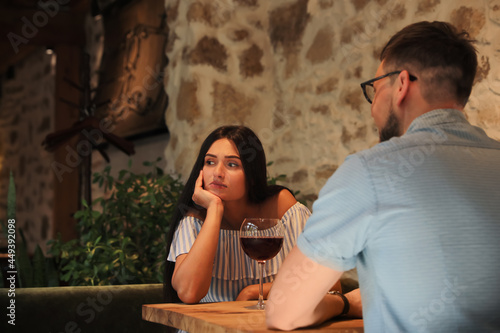 Obraz na plátne Young woman getting bored during date with man at cafe