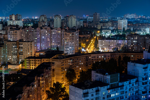 Night cityscape  lights from the windows of houses  stars in the sky  sleeping area. High quality photo