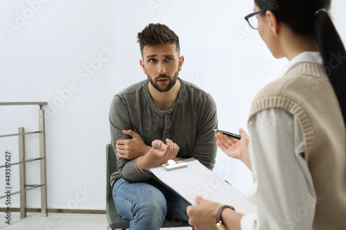 Psychotherapist working with drug addicted man indoors photo