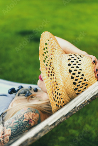 White Woman Relaxing on Hammock in Straw Summer Hat