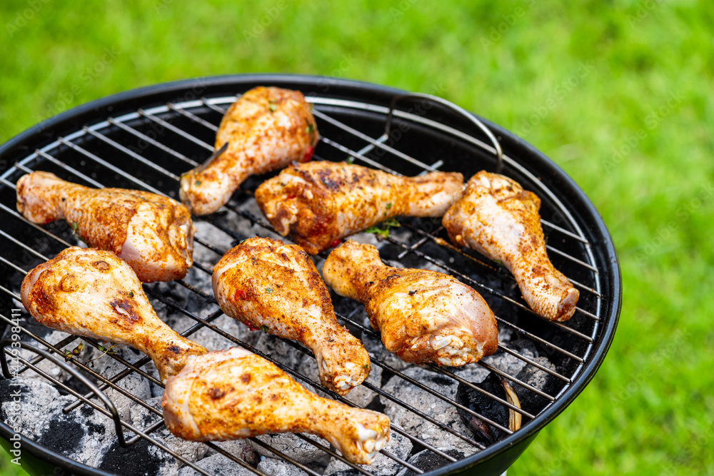 Chicken Drumsticks Legs Grilled on Charcoal BBQ in Backyard Garden at Summer Picnic Chicken Drumsticks Legs Grilled on Charcoal BBQ in Backyard Garden at Summer Picnic