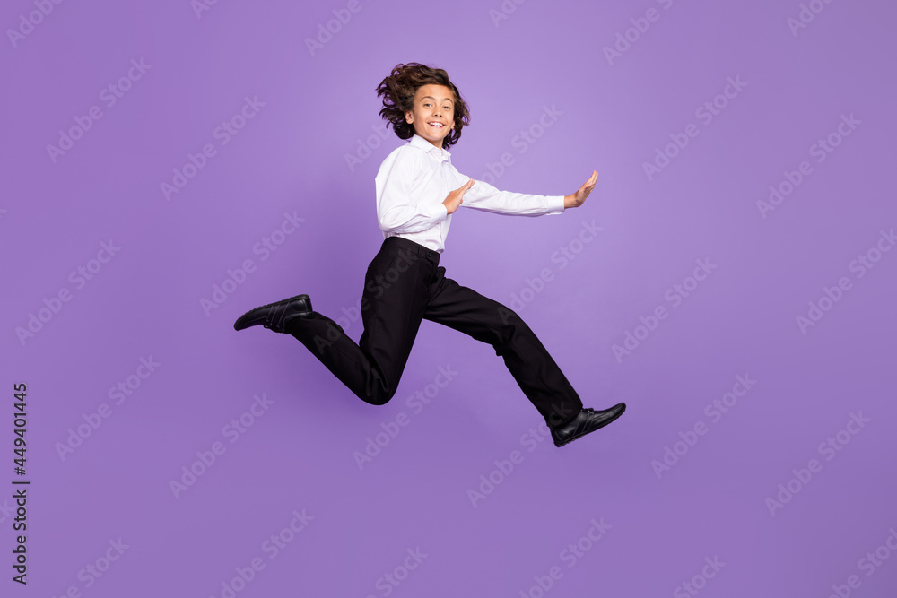 Full size photo of cool little brunet boy jump fight wear shirt trousers sneakers isolated on purple background