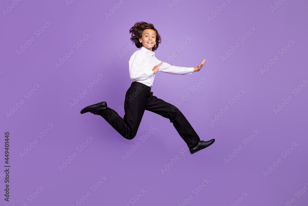 Full size photo of cool little brunet boy jump fight wear shirt trousers sneakers isolated on purple background Full size photo of cool little brunet boy jump fight wear shirt trousers sneakers isolated on purple background