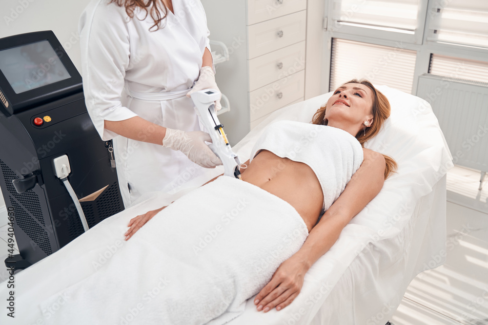 Obraz premium Smiling woman removing scar in medical clinic