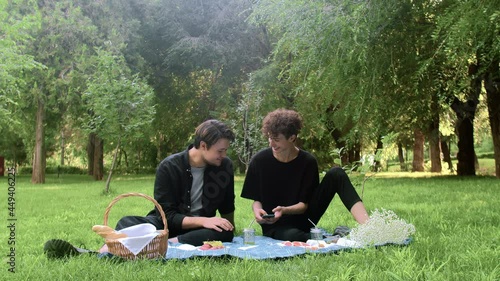 Two young guys looking at the phone in nature in the summer