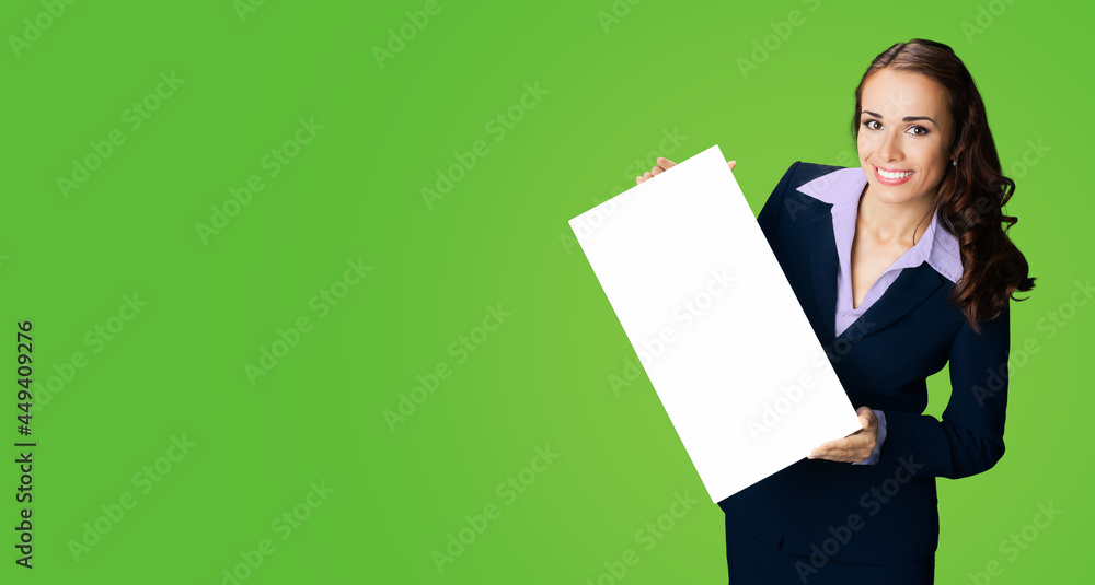 Happy smiling woman in black confident suit showing holding mock up white signboard. Business and advertising concept. Copy space empty free place for text. Green color background.. Happy smiling woman in black confident suit showing holding mock up white signboard. Business and advertising concept. Copy space empty free place for text. Green color background..