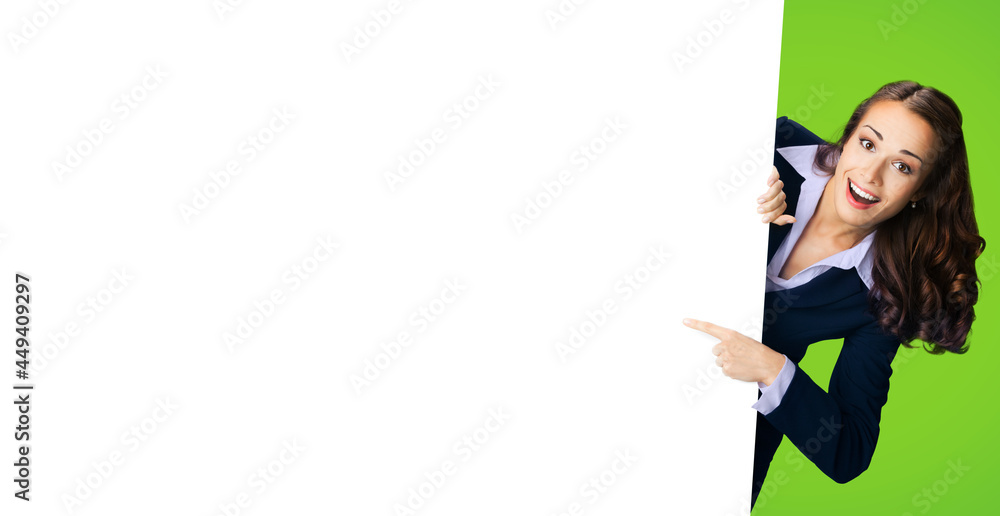 Happy excited woman in black confident suit showing pointing mock up white banner signboard. Business and advertising concept. Copy space free place for text. Green color background.. Happy excited woman in black confident suit showing pointing mock up white banner signboard. Business and advertising concept. Copy space free place for text. Green color background..