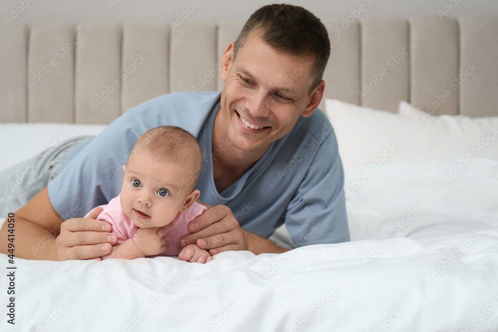 Happy father with his cute baby on bed at home Happy father with his cute baby on bed at home