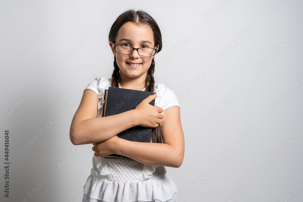 Brunette little girl reading a book isolated on a over white background Brunette little girl reading a book isolated on a over white background