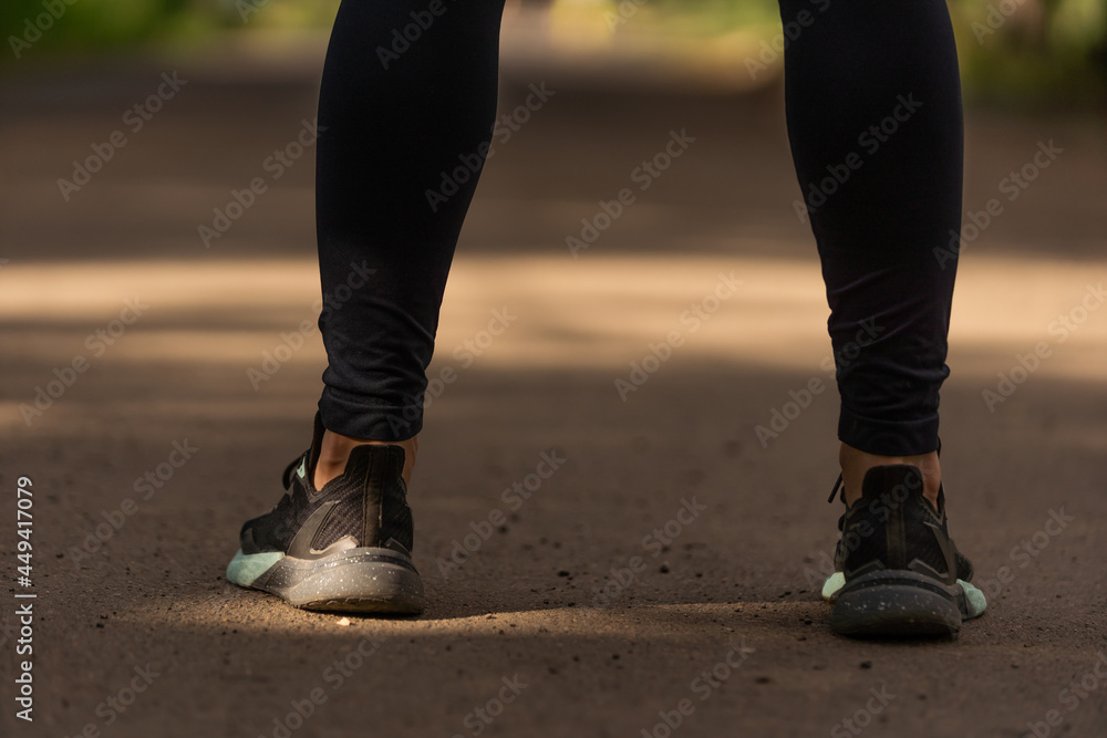 Runner feet running on road closeup on shoe. woman fitness sunrise jog workout welness concept. Runner feet running on road closeup on shoe. woman fitness sunrise jog workout welness concept.