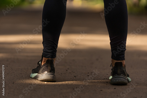 Runner feet running on road closeup on shoe. woman fitness sunrise jog workout welness concept.