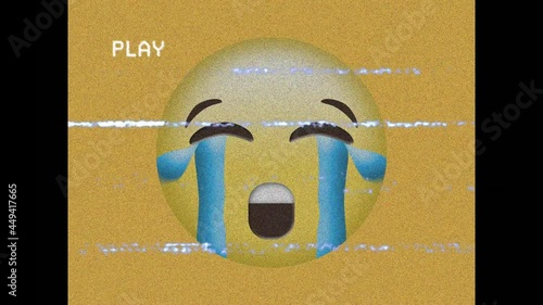 Digital animation of vhs glitch effect over crying face emoji on yellow background photo