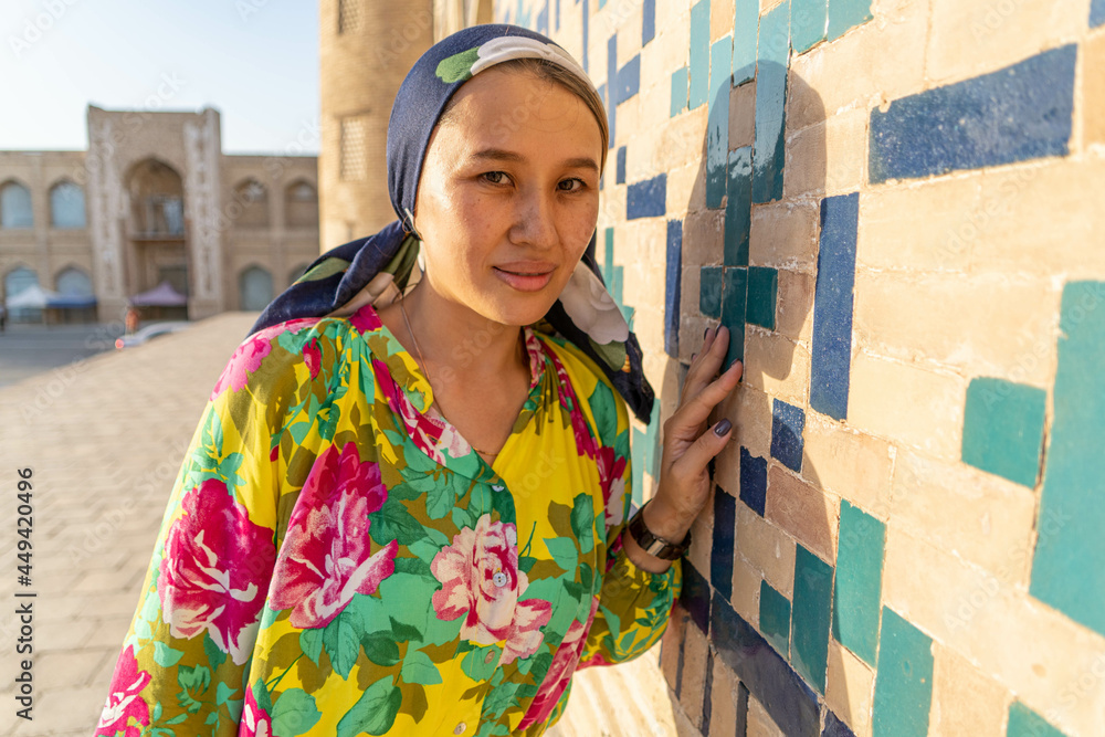 Muslim girl with a scarf on her head at the gate of the old mosque ...