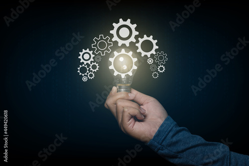Businessman holding light bulb with a gear icon. The idea of ​​inspiration online technology. innovation idea concept.
