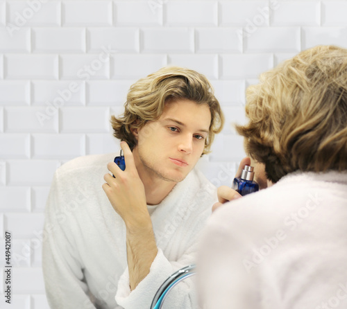 young man looking in the mirror,combing his hair,looking at problems on face.