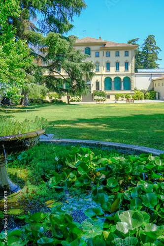 Fondation Magnani Rocca in Parma, Italy. Beautiful building of museum across garden with fountains, flowers, trees, and bushes. photo