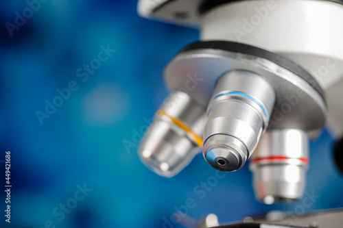 Close up shot of microscope lens and colorful blur blue background copy space